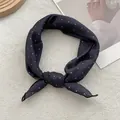 Detail of silk-like dark blue square scarf with white polka dots tied in an elegant knot - Black