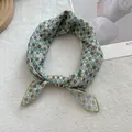 Detail of floral cotton linen scarf with gold-stitched edges on white plush background - Yellow
