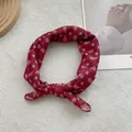 Close-up of wine red paisley print cotton linen small square scarf tied as hair accessory - Red