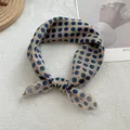 Close-up of elegant polka dot silk scarf tied in a bow on a white textured background - 58*58cm / Navy Blue Polka Dots