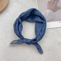 Close-up of a knotted navy blue silk scarf with golden paisley patterns on plush carpet - 58x58cm / Navy Blue