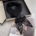 Detail of elegant black lace skinny scarf with intricate floral embroidery and pointed ends - Black