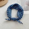 Detailed close-up of a blue polka dot cotton linen neck scarf tied in a neat bow - 58*58cm / Azure Polka Dot