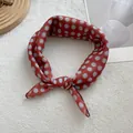 Detailed view of retro brick red silk scarf with blue polka dots tied in a bow - 58*58cm / Grey Polka Dot