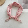 Detailed close-up of pink polka dot cotton scarf on a decorative wooden tray - Red Dot