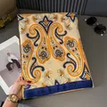 Detailopname van een elegante zijden sjaal met klassieke paisley-patronen in oranje - Blauw-Oranje Combinatie Stijl / Blauw