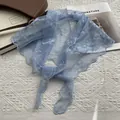 Dettaglio bandana in pizzo celeste con ricamo floreale bianco su sfondo strutturato - Blu