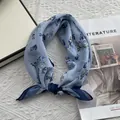 Detalle de un pañuelo de seda azul claro con flores sobre un libro de arte de Matisse - Azul