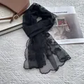Close-up of elegant black lace scarf with delicate floral embroidery and scalloped edges - Black