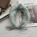 Dettaglio di un foulard di cotone a quadri verde chiaro su una borsa a mano elegante - 58x58cm / Verde