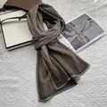 Detalle de la textura plisada marrón oscuro de la bufanda con borde y tacto de lino - Café Claro