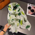 Detailed macro view of beige cotton linen scarf with green watercolor dots and gold foil - Green