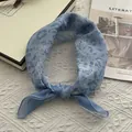 Close-up of light blue paisley and leopard print bandana on a white textured background - 58x58cm / Blue
