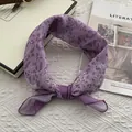Detailed view of lilac leopard print square scarf with paisley patterns on white surface - 58x58cm / Purple