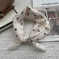 Dettaglio ravvicinato di un foulard a pois con texture morbida annodata e bordo rifinito - 58*58cm / Bianco Sporco