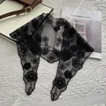 Close-up of black lace triangle scarf with floral embroidery and artistic lettering details - 88x26cm / Black