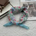 Vue détaillée du foulard en coton et lin à fleurs avec bordure bleu clair sur magazine - Marguerite Bleue