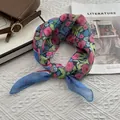 Close-up of floral linen-cotton small square scarf with fine rolled edges and vibrant print - Medium / Blue