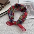 Close-up of floral print cotton linen neckerchief on a white knit background - Medium / Red
