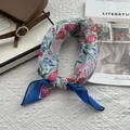 Vue détaillée d'un foulard floral en coton et lin sur un fond texturé avec accessoires - Lycoris Bleu
