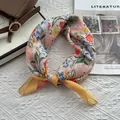 Détails d'un foulard noué en lin-coton pêche avec imprimé floral et bordure jaune - Lycoris Jaune