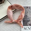 Close-up of peach paisley cotton-linen scarf tied in a knot on a decorative table - 58cm x 58cm / Orange Gradient