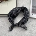 Eleganter schwarzer Seidenschal mit weißem Blumenmuster auf Texturhintergrund - Schwarz