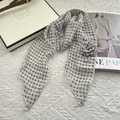 Detail of a thin chiffon scarf with paisley pattern and a decorative fabric flower - Paisley White