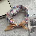 Primo piano di una sciarpa in cotone e lino con stampa di margherite rosse e bordo arancione - 58x58cm / Bianco