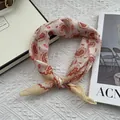 Detail van een beige katoenen bandana met paisley-patronen op een geweven achtergrond - 58*58cm / Oranje