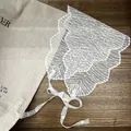 Détail du bonnet en dentelle florale blanche avec bords festonnés et broderies - Style Météore / Blanc