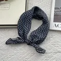 Detail of navy blue teardrop paisley scarf knotted on luxury gift box and magazine - Standard Square / Navy Blue