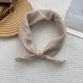 Gros plan détaillé d'un foulard beige à pois en lin et coton noué sur un plateau en bois - 58*58cm / Blanc Cassé