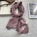 Detail of mauve linen blend long scarf with white fabric label and stylish leather buckle - 170x45cm / Pink