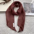 Detail of thin red-brown checkered linen scarf paired with a brown leather handbag - Red Plaid
