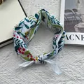 Detail of floral linen headscarf with botanical prints and a decorative knot detail - White Berry Floral