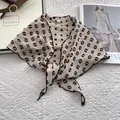 Detailaufnahme des beigen Leinen-Halstuchs mit schwarzen Punkten und feiner Nahtkante - Khaki