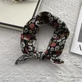 Detail of floral cotton neckerchief featuring daisy print and white stitched edges - Black Floral