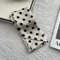 Close-up of elegant cream silk scarf with large black polka dots on a textured background - Large Polka Dot Beige