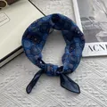 Detailed close-up of blue floral print silk scarf displayed on a white woven background - 58cm*58cm / Blue