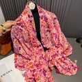 Detail of thin floral scarf featuring pink and purple prints with matching fringe tassels - Red