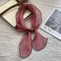 Λεπτομέρεια από λινό καρό φουλάρι δεμένο σε φιόγκο πάνω σε λευκό ανάγλυφο ύφασμα - Μικρό Καρό Κόκκινο
