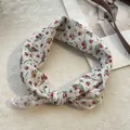 Kleines Baumwoll-Leinen-Halstuch mit Blumenmuster als Schleife auf einem Magazin - Rote Kleine Pflaumenblüte