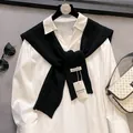 Detail eines weißen Baumwollhemdes mit schwarzem Strickschal und Modeaccessoires - Schwarz