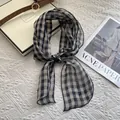 Close-up detail of the breathable linen texture and classic black and white plaid scarf pattern - Large Plaid Black