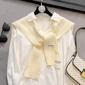 Detailed view of cream-colored hollow knit shawl with premium textured woven pattern - Off White