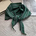 Detalle de bandana a rayas verde oscuro anudada con estilo sobre un fondo de tela blanca - 28*115cm / Verde