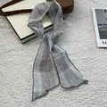 Elegant grey plaid skinny silk scarf for women styled with a minimalist leather handbag - Gray