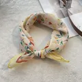 Détail d'un foulard en coton noué à motif floral avec bordure jaune sur fond blanc - 58*58cm / Jaune