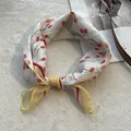 Close-up of tulip floral print cotton linen scarf with elegant yellow rolled hem edges - Yellow
